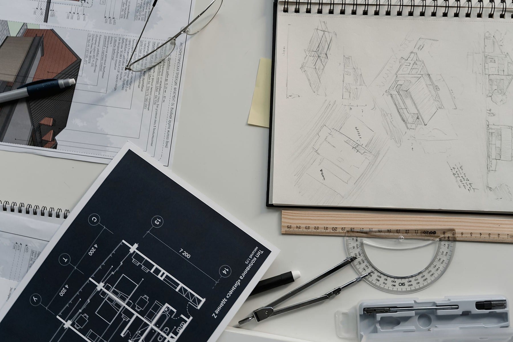 Engineering drawings, technical sketches, and drafting tools on a working desk